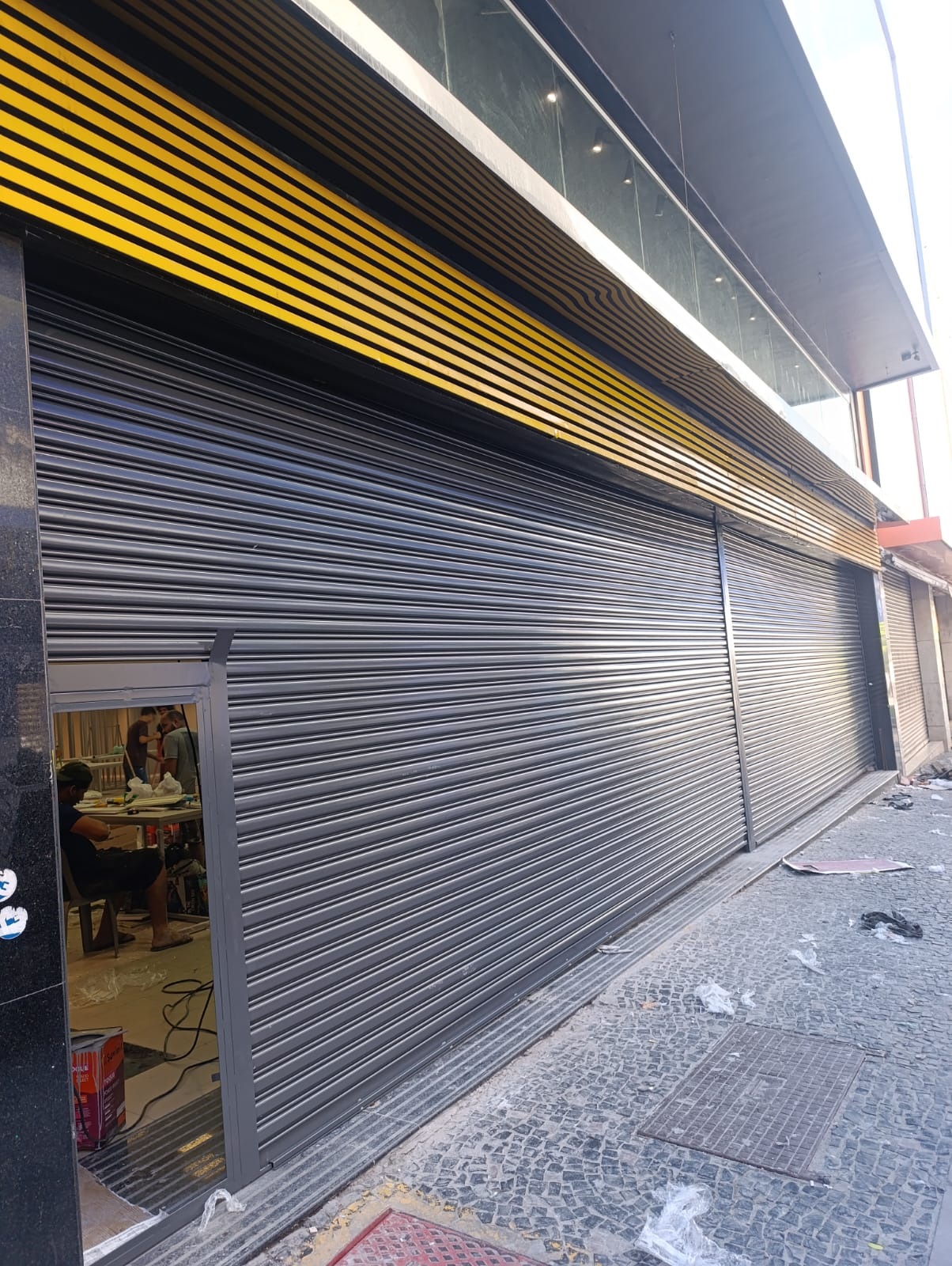 Técnico da Rápido Portas realizando conserto emergencial de porta automática à noite – atendimento 24h em Ribeirão Preto